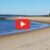 A person is walking on a sandy beach near Salisbury Beach Webcam.